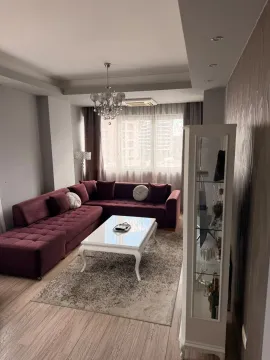 Prostrani dnevni boravak sa ljubičastom ugaonom garniturom i bijelim klub stolićem. - image 15