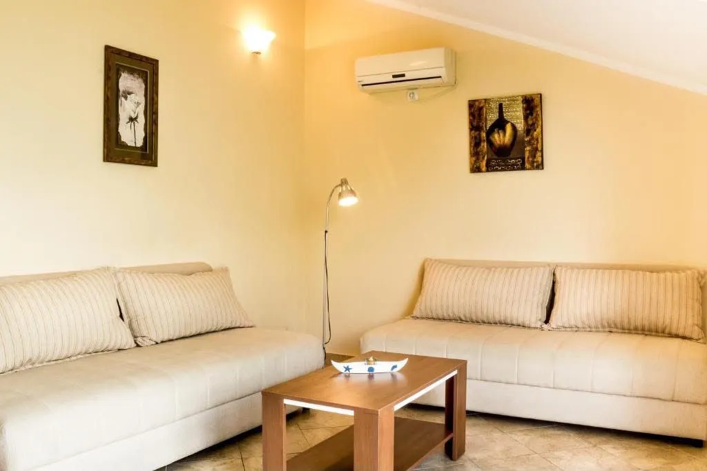 Living room with two beige sofas, a coffee table, and an air conditioner.