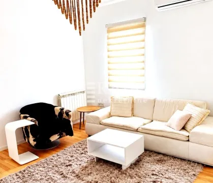 Bright living room with a sofa, armchair, and rug. - image 2