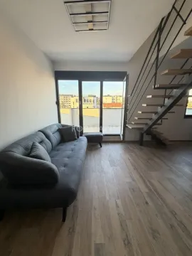 Living room with a grey sofa, staircase, and access to the terrace. - image 14