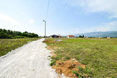 View of the plot and access road with surrounding houses and nature. - image 4