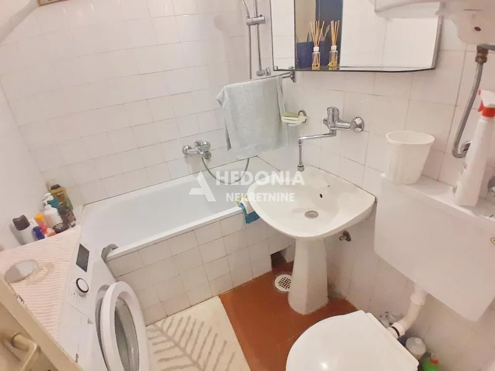Manje kupatilo sa kadom, umivaonikom i WC šoljom.