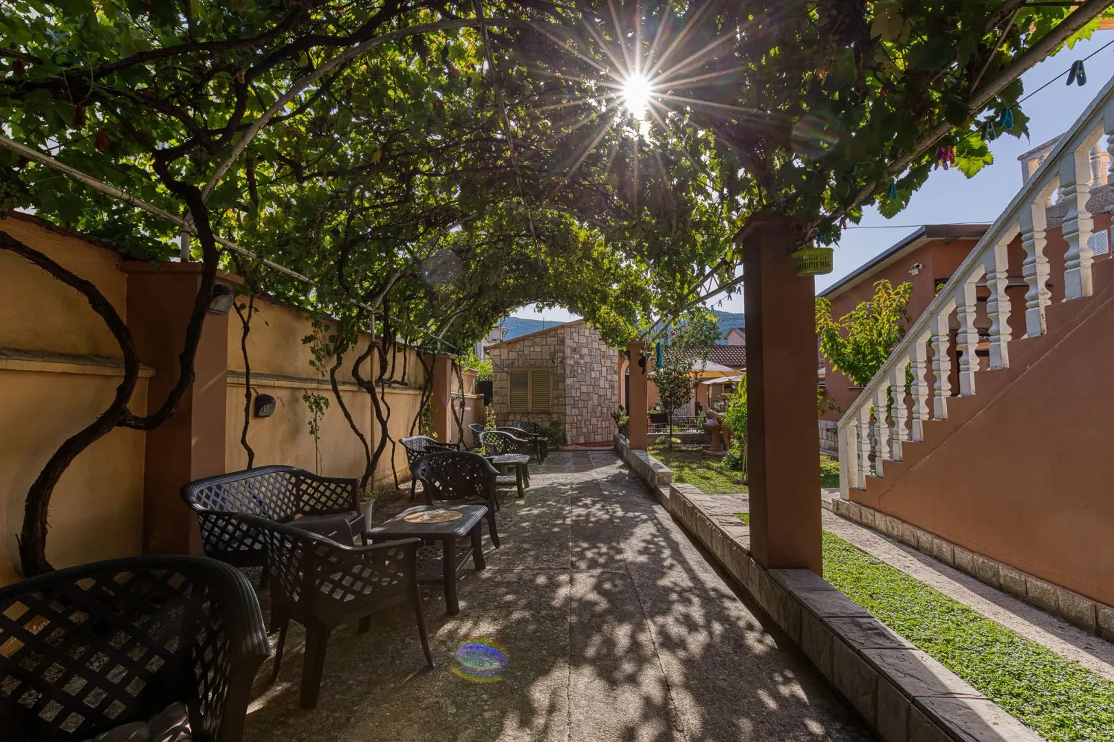 Natkrivena terasa sa garniturom za sjedenje u dvorištu kuće.