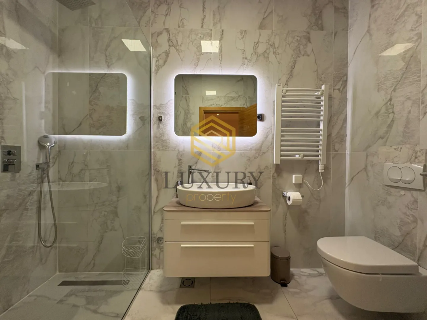 Moderno opremljeno kupatilo sa umivaonikom, tuš kabinom i wc šoljom.