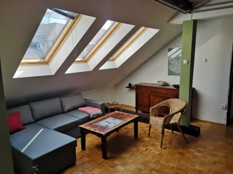 Attic living room with a sofa set and roof windows. - image 2