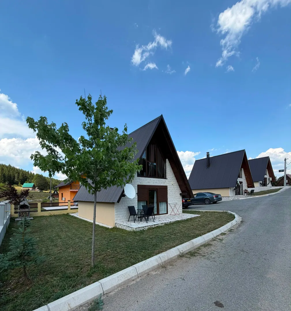 Pogled na eksterijer vikendice sa dvoriijem i terasom.
