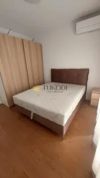 Bedroom with a double bed, wooden wardrobe and air conditioning unit. - image 10