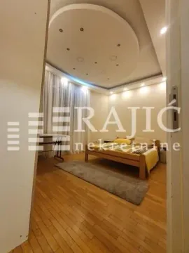 Bedroom with a double bed, hardwood flooring, and a decorative drop ceiling. - image 6
