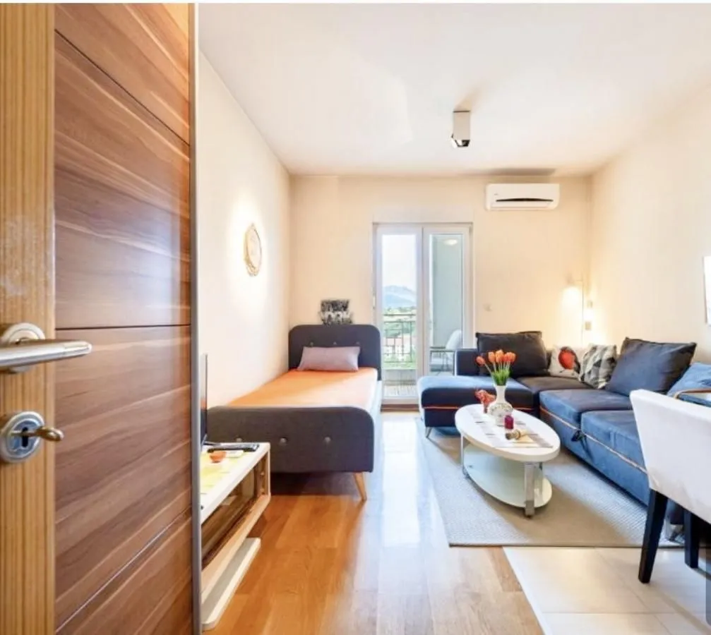 Living room with a bed, sectional sofa and access to the terrace.