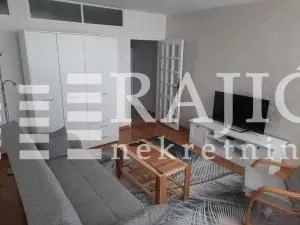 Living room with a sofa, TV, and wardrobe. - image 2