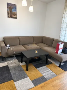 Ugaona garnitura u dnevnoj sobi sa klub stočićem i šarenim tepihom. - image 3