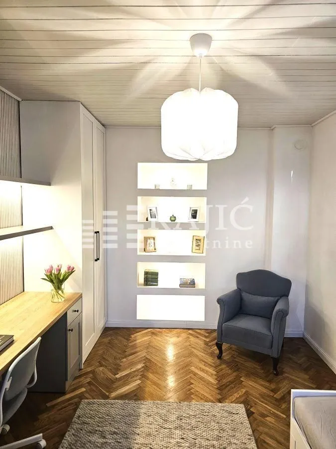 Furnished bedroom with a desk and an armchair.