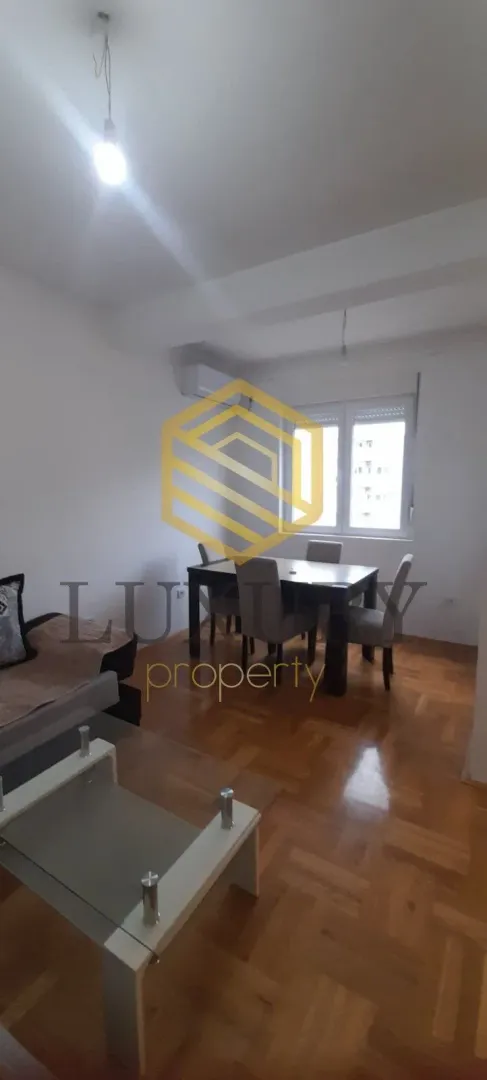 Living room with a dining area and parquet flooring.