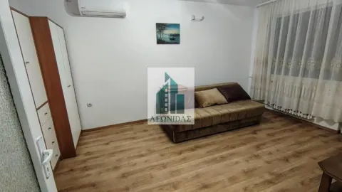 Bedroom with a sofa bed, wooden wardrobe, and laminate flooring. - image 5