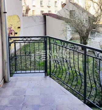 Terrace with metal railing and a view of the courtyard. - image 6