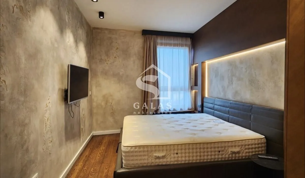 Modern bedroom with a double bed and decorative lighting.