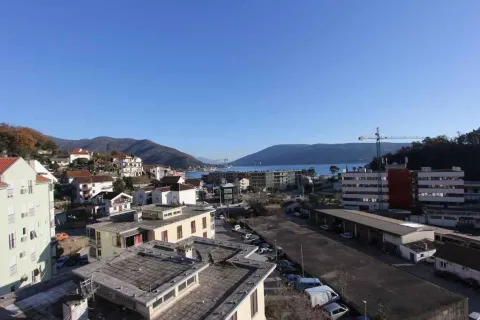 Pogled na gradsko naselje i more sa brdima u pozadini. - image 2
