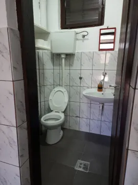 Small bathroom with a toilet and a washbasin. - image 11