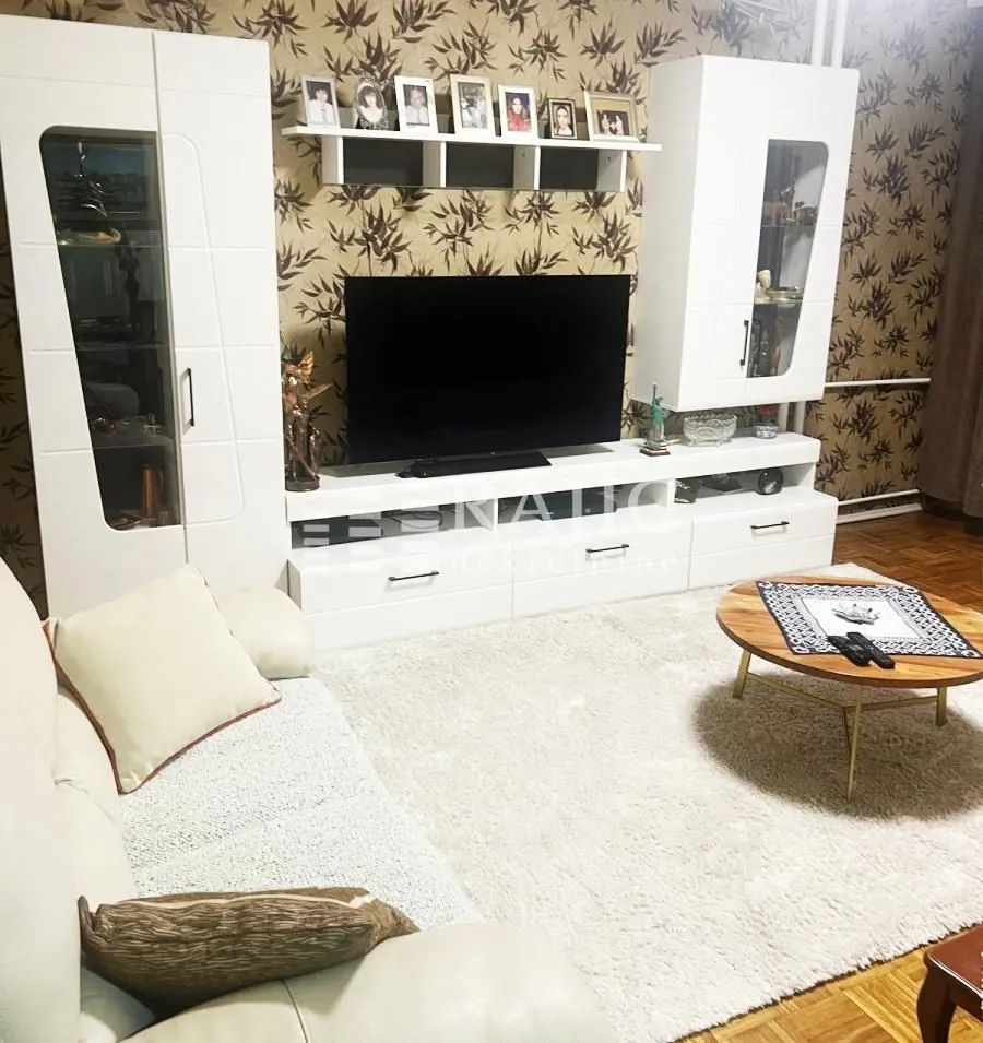 Dnevna soba sa garniturom, TV komodom i stočićem.