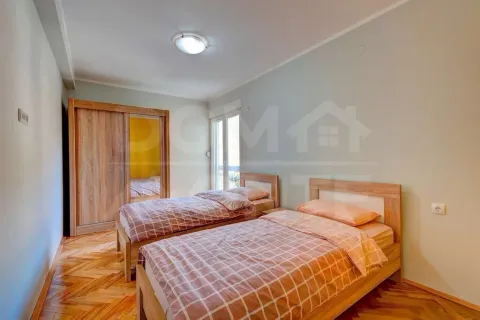 Furnished bedroom with two single beds and a wooden wardrobe. - image 6