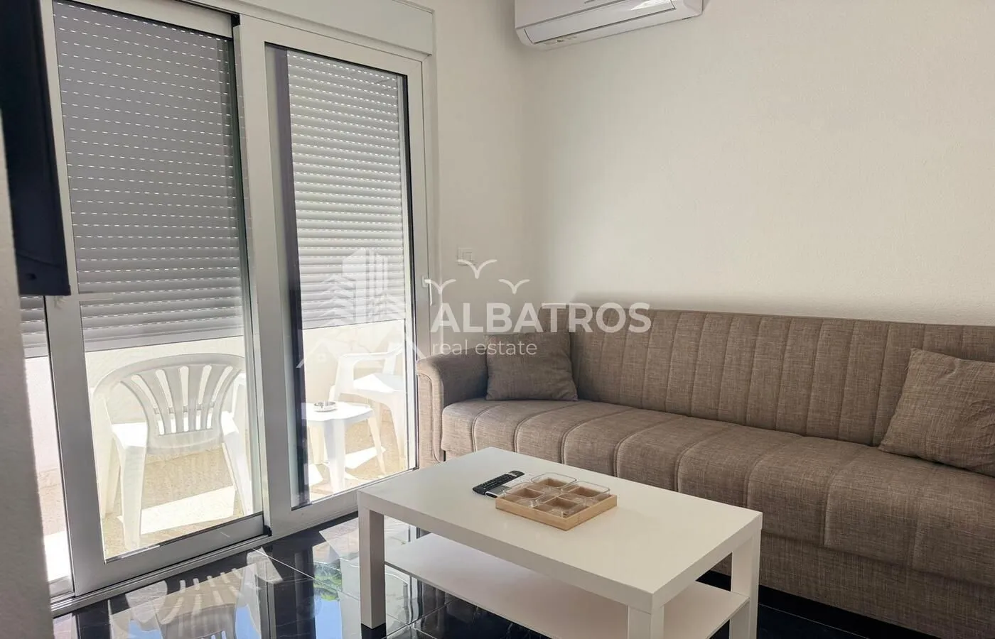 Living room with a sofa, coffee table, and access to the terrace.