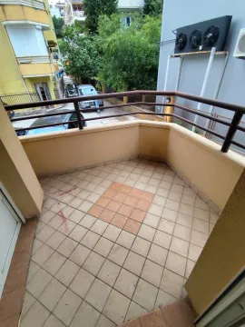 Prazan popločani balkon sa metalnom ogradom i pogledom na ulicu. - image 4