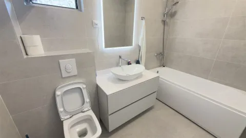 Moderno kupatilo sa kadom, lavaboom i toaletom u svijetlim tonovima. - image 10