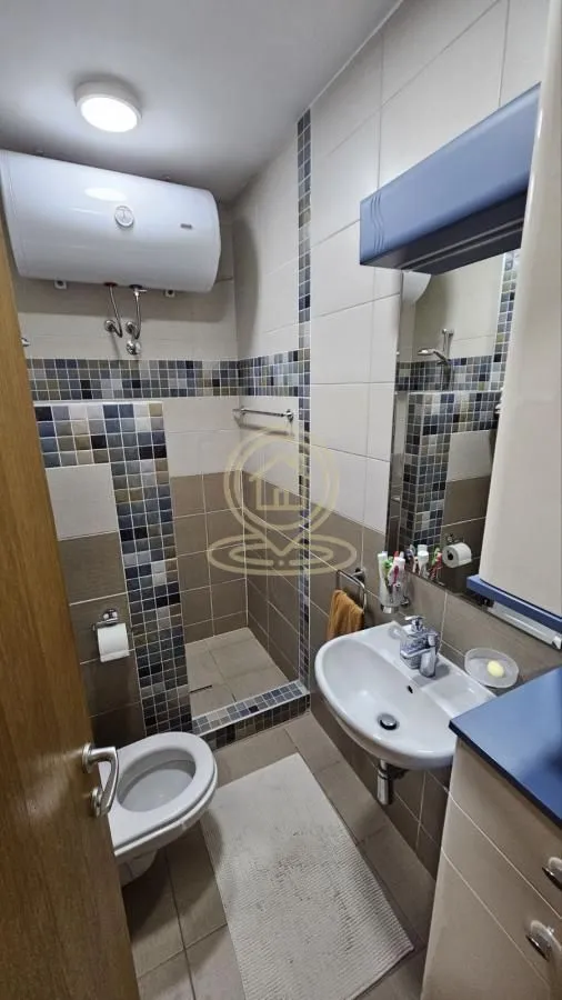 Compact bathroom with a shower cabin, washbasin, and toilet.