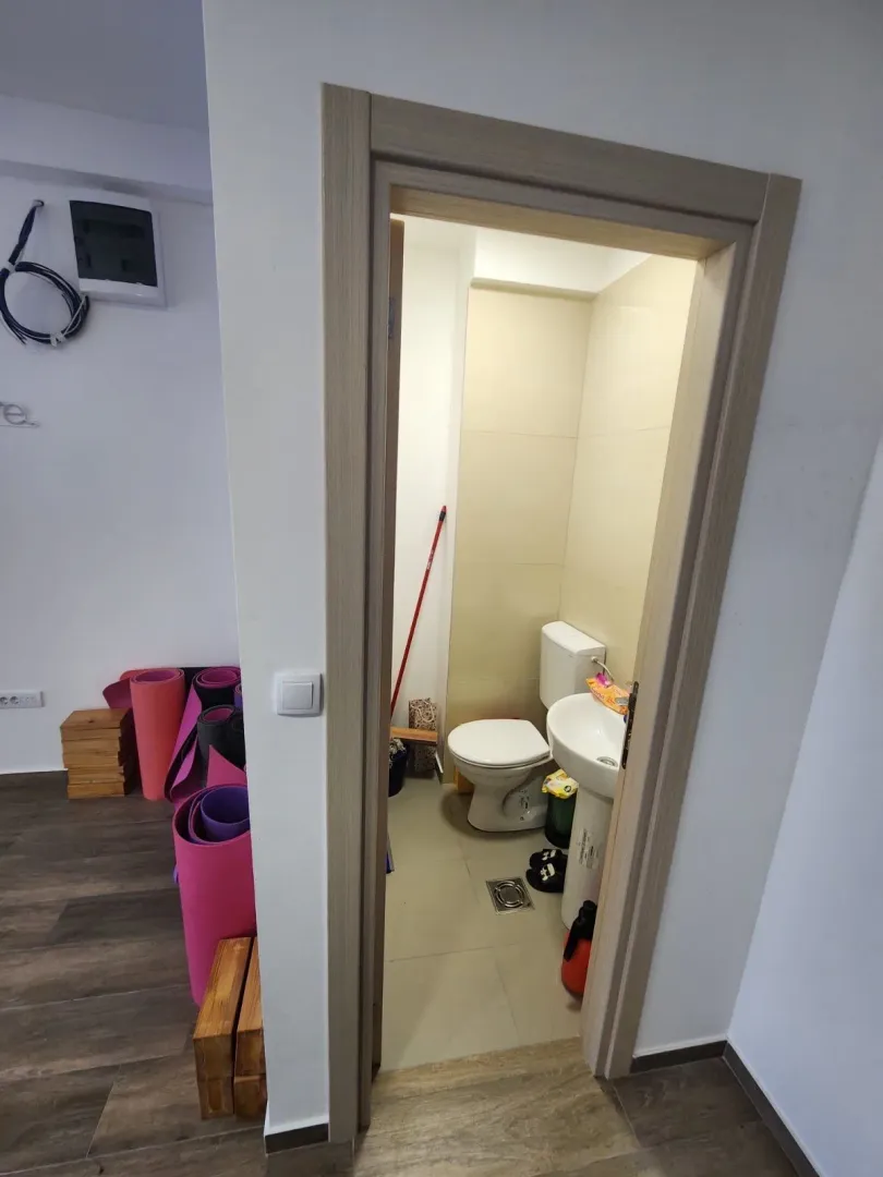 View through the doorway into a small bathroom with a toilet and sink.