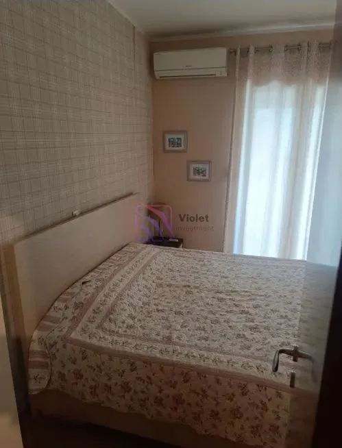 Namještena spavaća soba sa bračnim krevetom i klima uređajem.