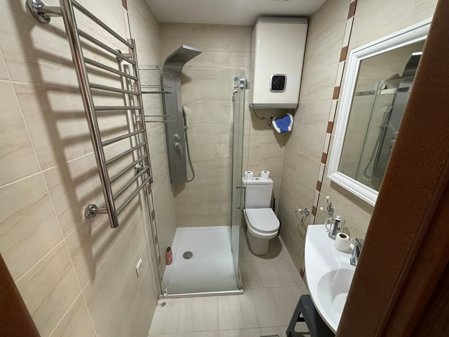 Manje kupatilo sa tuš kabinom, umivaonikom i wc šoljom.