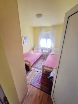 Manja spavaća soba sa dva krevetom i prozorom. - image 14