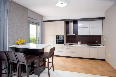 Modern kitchen with a bar counter and built-in appliances. - image 11
