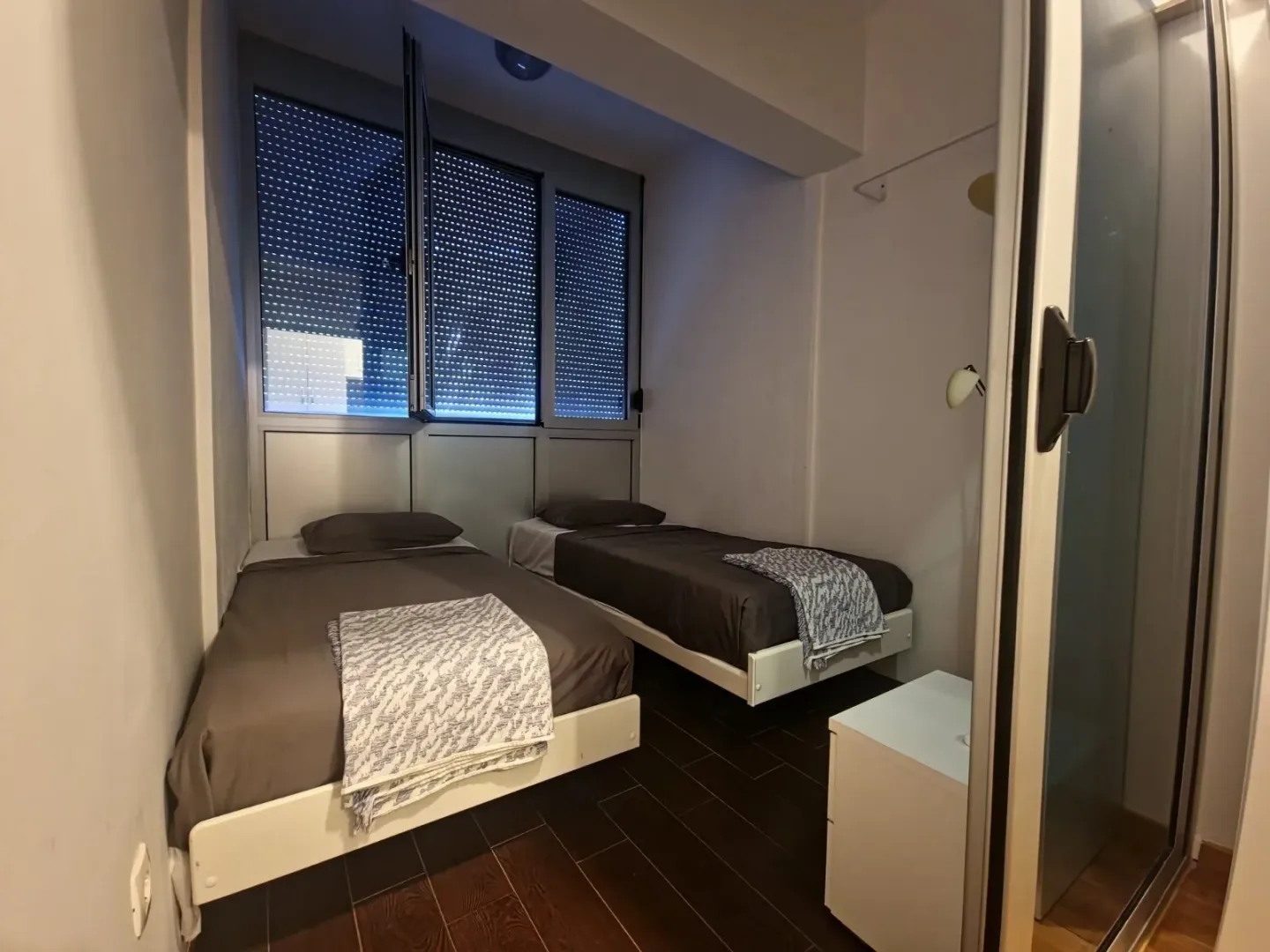 Bedroom with two single beds and a large window.