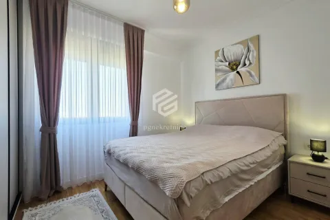 Furnished bedroom with a double bed, nightstand, and a window with curtains. - image 9
