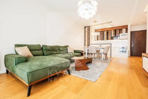 Living room with a sofa connected to the dining area and kitchen. - image 2
