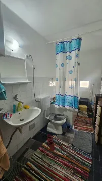 Manje uredno kupatilo sa umivaonikom, wc šoljom i tuš zavjesom. - image 10
