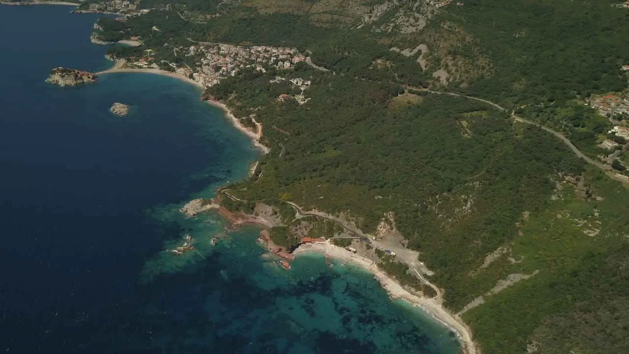 Pogled iz vazduha na obalu mora i šumoviti pejzaž.
