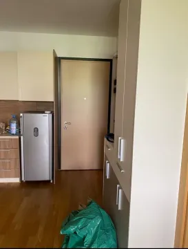 Small kitchen with a refrigerator and an entrance door in the background. - image 3
