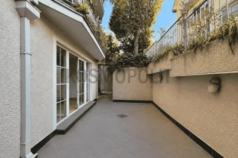 Tiled courtyard with building access and a high wall. - image 6
