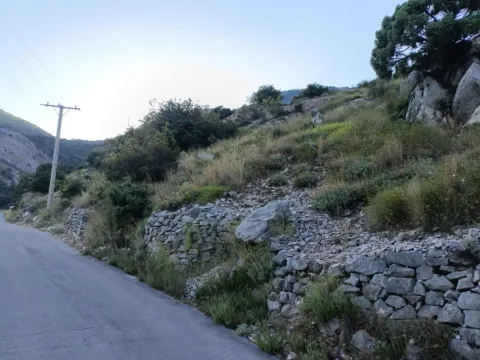 Pogled na plac i teren pored asfaltnog puta sa kamenim podzidima. - image 3