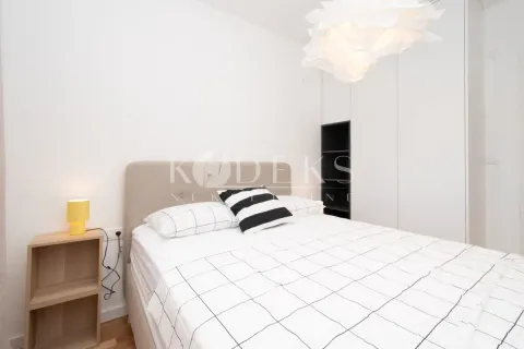 Svjetla spavaća soba sa bračnim krevetom, bijelim plakarom i noćnim stočićem. - image 4