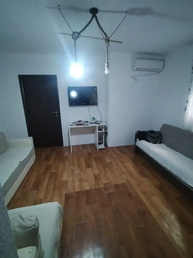 Living room with a sofa set, desk, and wall-mounted TV.