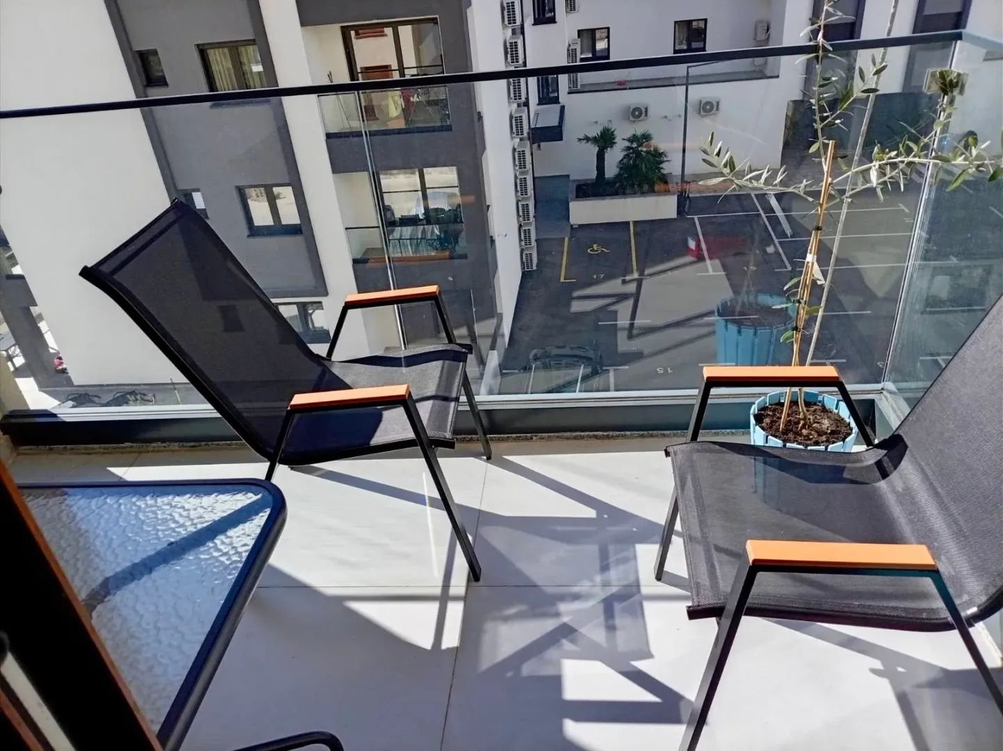 Furnished balcony with loungers and a view of the building courtyard.