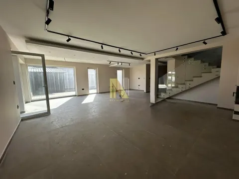 Spacious unfurnished living room with staircase and modern lighting. - image 2