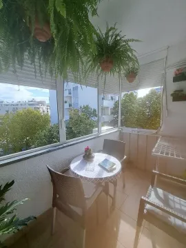 Zastakljeni balkon sa garniturom za sjedenje i visećim biljkama. - image 3