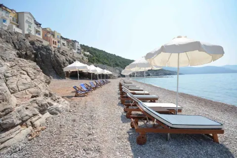 Plaža sa ležaljkama i suncobranima pored zgrade. - image 10
