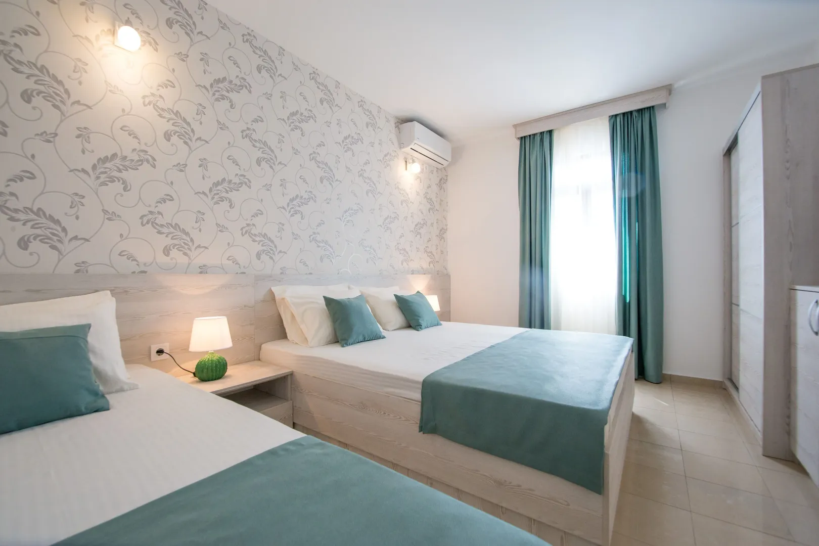 Furnished bedroom with a double bed, a single bed, and a wardrobe.
