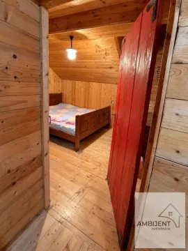 Potkrovlje sa drvenim zidovima i plafonom u kojem se nalazi krevet. - image 15