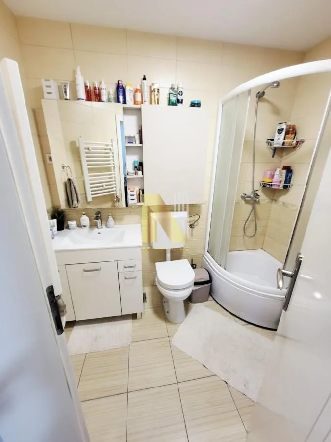 Kupatilo opremljeno tuš kabinom, umivaonikom i WC šoljom.
